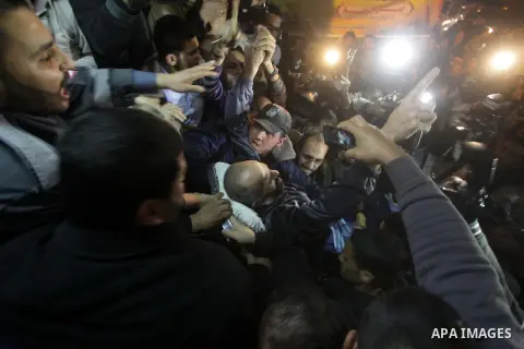 Palestinians carry freed Palestinian prisoner Ayman Sharawna on a stretcher as he gestures upon his arrival to al-Shifa Hospital in Gaza City March 17, 2013. The 36-year-old Ayman Sharawna arrived to Gaza after more than...