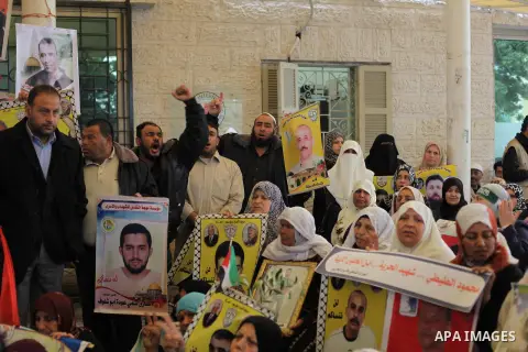 Palestinians take part in a protest in front of the Red Cross building in Gaza City, in solidarity with hunger-striking detainees held by Israel to demand their release from detention without trial,on March 18, 2013. Pho...