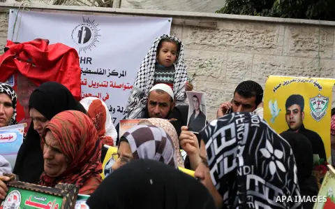 Palestinians take part in a protest in front of the Red Cross building in Gaza City, in solidarity with hunger-striking detainees held by Israel to demand their release from detention without trial,on March 18, 2013. Pho...