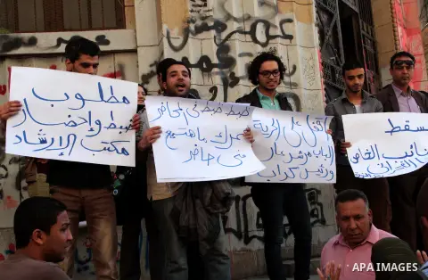 Egyptian protesters hold placards during a demonstration in support with the lawyer Hamdy Fakharany demanding for release him in front of the High Court, in Cairo on March 27, 2013. Photo by Tareq Gabas