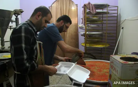 Palestinian former prisoners Hamouda Salah and Radwan Abu Turki, make Kunafa at their sweet store in Gaza city on March 29, 2013. Salah and Abu Turki was released by Israel as part of the Gilad Shalit prisoner exchange a...