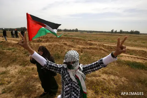 A Palestinian boy waves his national flag during a protest in Rafah, southern Gaza Strip, on March 30, 2013. Land Day commemorates the death of six Arab Israeli protesters at the hands of Israeli troops during mass prote...