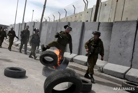 Israeli soldiers take position during clashes with Palestinian protestors at the Qalandia checkpoint, in the occupied West Bank on March 30, 2013. Land Day commemorates the death of six Arab Israeli protesters at the han...