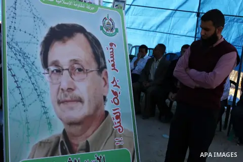 A Palestinian man looks at a portrait of prisoner Maisara Abu Hamdiyeh during a protest following his death in Gaza city on April 2, 2013. The Palestinian leadership blamed Israel for the death of Maisara Abu Hamdiyeh, a...
