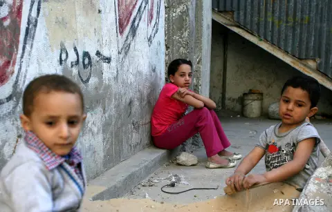 Palestinian children play outside their homes in Rafah refugee camp, in the southern Gaza strip on April 09, 2013. The United Nations said it will reopen aid distribution centres in Gaza, after a four-day closure in resp...