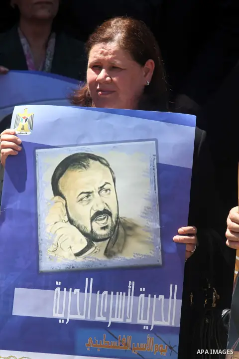 Fadwa Barghouti the wife of the deputy in the Palestinian Council and the prisoner Marwan Barghouti, carries his picture during a rally marking the eleventh anniversary of his arrest outside the Palestinian Legislative C...