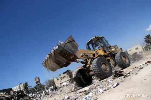 A Palestinian labourer uses bulldozer during working in a destroyed governmental building destroyed by the Isreali airstrikes during the conflict between Israel and Gaza militants on November 2012, in Gaza city on April...