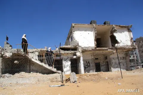 A Palestinian woman stands next to the rubble of a destroyed governmental building destroyed by the Isreali airstrikes during the conflict between Israel and Gaza militants on November 2012, in Gaza city on April 16, 201...