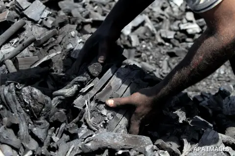 A Palestinian worker removes coal from a pile at one of the few local charcoal manufacturing shops east of Gaza City on April 16, 2013. In adapting to years of border blockades and shortages, Gazans have become experts a...