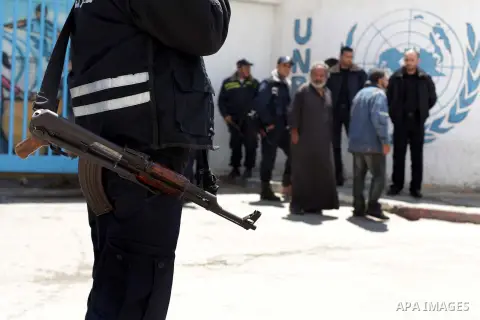 Palestinians refugee stand outside the gate of the United Nations Relief and Works Agency (UNRWA) headquarters during a protest to demand the resumption of financial aid for refugees, in Gaza City April 22, 2013. Robert...