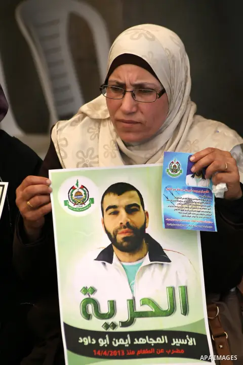 Palestinian women hold pictures of prisoners held in Israeli jails during a protest in front of the Red Cross offices in the West Bank city of Hebron, on Apr. 29, 2013 in solidarity with Palestinian prisoners held by Isr...