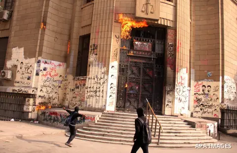 Egyptian masked members of the Black Bloc movement throw molotov cocktail at the High court building, in Cairo on May 03, 2013. Photo by Tareq Gabas