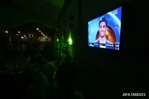 Fans of Palestinian singer Mohammad Assaf, watch him on television as he performs in the Arab Idol competition at a cafe shop in Rafah in southern Gaza strip on May 03, 2013. Photo by Eyad Al Baba