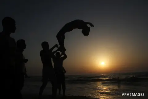 Palestinian boys enjoy playing in the sea at Gaza beach during hot weather in Gaza city, May 03, 2013. Gazans escape to the beach and out from their homes during heat wave and power outages. Photo by Ezz al-Zanoon