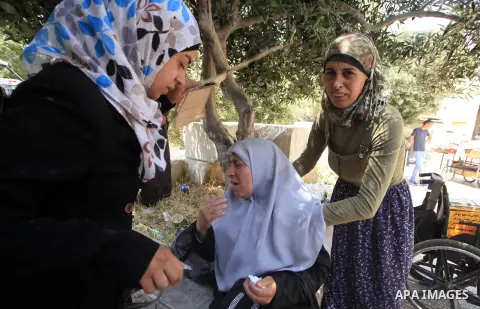 A Palestinian woman reacts after Israeli forces sprayed pepper gas at people gathering at one of the entrances to the al-Aqsa mosque compound on May 7, 2013 as police restricted the number of people entering the Muslim h...