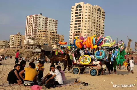A Palestinian vendor on a beach in Gaza beach during Friday holiday in Gaza city, May 10, 2013. Gazans escape to the beach and out from their homes during heat wave and power outages. Photo by Ashraf Amra