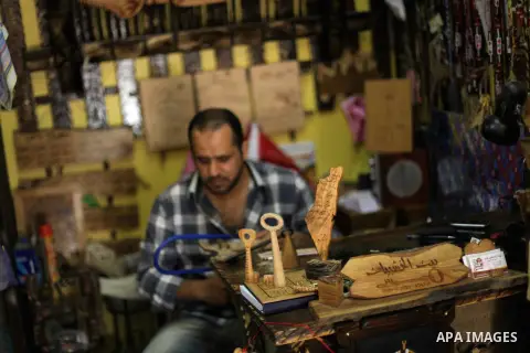 A Palestinian man works on wood keys at his souvenir shop in Gaza City on May 14, 2013. Palestinians will mark ''Nakba'' (Catastrophe) on May 15 to commemorate the expulsion or fleeing of some 700, 000 Palestinians from...