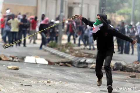 A Palestinian protester hurls stones towards Israeli security forces during clashes to mark Nakba Day outside Ofer military prison near the West Bank city of Ramallah May 15, 2013. Palestinians clashed with Israeli force...