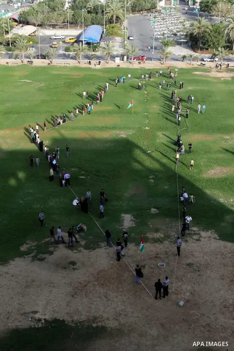 Palestinian youth stand shaping Palestine map during a rally marking the Nakba or the "Day of Catastrophe" commemorations in Gaza city, on May 15, 2013. Palestinians commemorate the "Nakba," when hundreds of thousands fl...