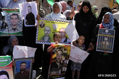 Palestinian woman hold pictures of prisoners held in Israeli jails during a protest at inside Red Cross office in Gaza City, on May. 20, 2013 in solidarity with Palestinian prisoners held by Israel to demand their releas...