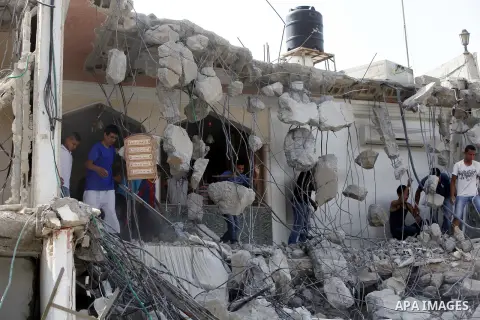 Palestinians search through the remains of the demolished house after it was demolished by Israeli bulldozers in the neighborhood of al-Tur in Israeli-occupied east Jerusalem on May 21, 2013, in implementation of a court...