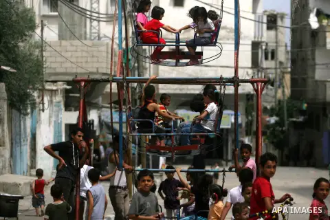Palestinian children play in the streets at Rafah City in the Gaza Strip on May 25, 2012. The children enjoy their summer holiday after they finished final exams. Photo by Eyad Al Baba