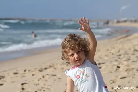 A Palestinian girl plays at the beach west of Gaza City, 26 May 2013. Gazans escape to the beach and out from their homes during heat wave and power outages. Photo by Mohammed Asad