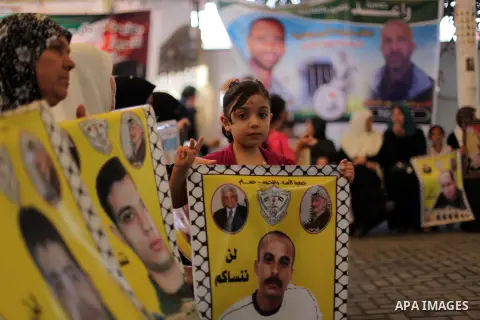 Palestinian children hold pictures of prisoners held in Israeli jails during a protest at inside Red Cross office in Gaza City, on May. 27, 2013 in solidarity with Palestinian prisoners held by Israel to demand their rel...