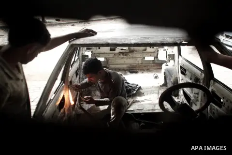 Young Palestinians repair a car in the town of Beit Lahiya, in northern Gaza, 29 May 2013. Child labor is widespread in the Gaza Strip because of the high rates of poverty and unemployment, according to reports. Photo by...