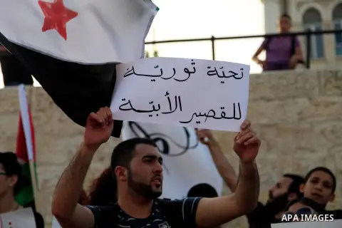 Palestinian protesters hold Syrian revolution flags during a demonstration against Syrian regime in front of Damascus gate, in Jerusalem's Old City on May 31, 2013. The EU formally modified its package of sanctions again...