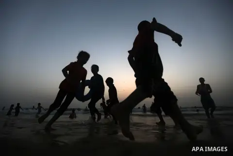 Palestinian children play on the beach during a sunny day on June 01, 2013 in Gaza City. Photo by Yasser Qudeh