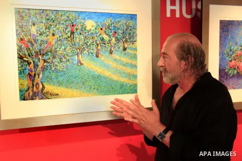 Palestinian artist Taleb Dweik explains his painting during his art show titled "Dreams" at Yabous cultural center, in Jerusalem on June 01, 2013. Dweik is an Jerusalemite artist with a unique style that is quickly recog...