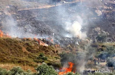 Palestinians try to put out fire in an olive grove near the West Bank village of Burin, near Nablus, Monday, June .3, 2013. Palestinian witnesses say Jewish settlers from Yitzhar settlement set fire to an olive grove. Pa...