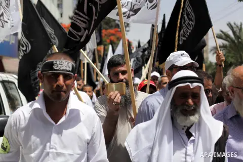 Palestinian supporters of Hizb ut-Tahrir wave black and white flags as they take part in a rally marking the 92nd anniversary of the fall of the Islamic Caliphate, in Gaza June 05, 2013. Photo by Ashraf Amra