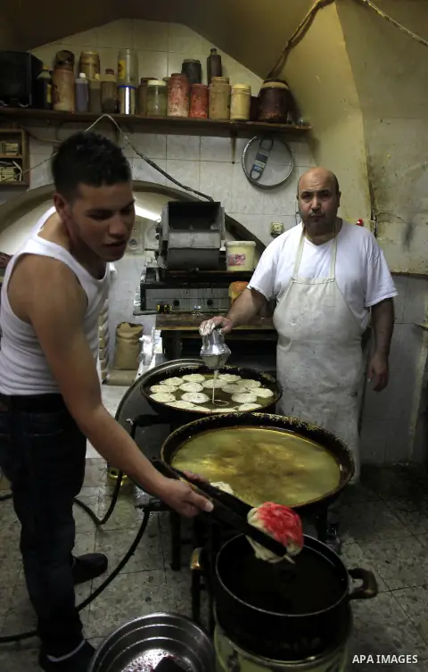 Palestinian workers make traditional sweets 'Mushabak', during celebration the Islamic holiday of Isra Mi'raj in Jerusalem on June 06, 2013. The holiday marks what Muslims believe is Prophet Mohammad's journey from Mecca...
