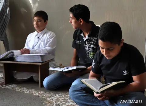 A blind Palestinian boy reads verses from the Quran during a class on how to read Islam's holy book, at a mosque in Gaza city, on June 8, 2013. A summer camp in the Gaza Strip, 'Crown of Dignity 5', plans to teach 2,000...