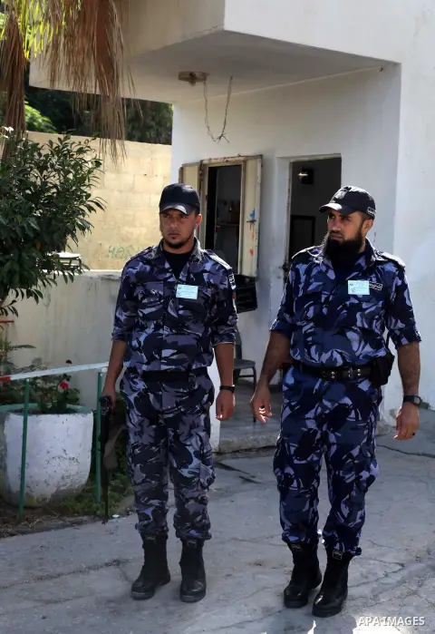 Palestinian policemen guard Palestinian students during a provide final high school exams, known as "Tawjihi", in Gaza City on June 15, 2013. Photo by Ashraf Amra