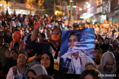 Palestinians watch the televised performance of Mohammad Assaf, a Palestinian finalist on the Arab Idol talent show, in the West Bank city of Ramallah, June 22, 2013. The 22-year-old Assaf, from the Gaza Strip, was named...