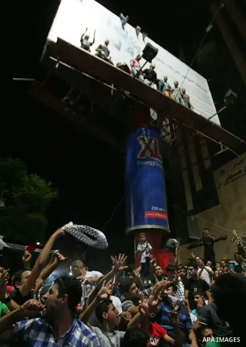 Palestinians celebrate after Palestinian singer Mohammed Assaf won a regional TV singing contest, in the West Bank city of Hebron, Saturday, June 22, 2013. Palestinians relished a rare moment of pride and national unity...