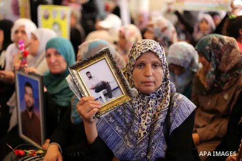 Palestinians hold pictures of prisoners held in Israeli jails during a protest outside Red Cross office in Gaza City, on June 24, 2013 in solidarity with Palestinian prisoners held by Israel to demand their release. Phot...