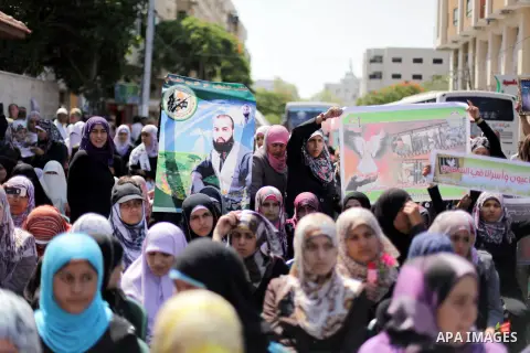 Palestinians hold pictures of prisoners held in Israeli jails during a protest outside Red Cross office in Gaza City, on June 24, 2013 in solidarity with Palestinian prisoners held by Israel to demand their release. Phot...