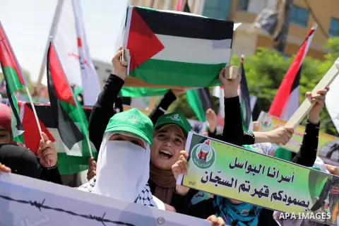 Palestinians hold pictures of prisoners held in Israeli jails during a protest outside Red Cross office in Gaza City, on June 24, 2013 in solidarity with Palestinian prisoners held by Israel to demand their release. Phot...