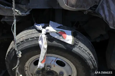 A Palestinian keffiyeh is seen on a tire of a crashed bus following an accident in Beit Lahia northern Gaza Strip, June 24, 2013. A Palestinian boy was killed and 25 others were wounded on Monday when a bus transporting...