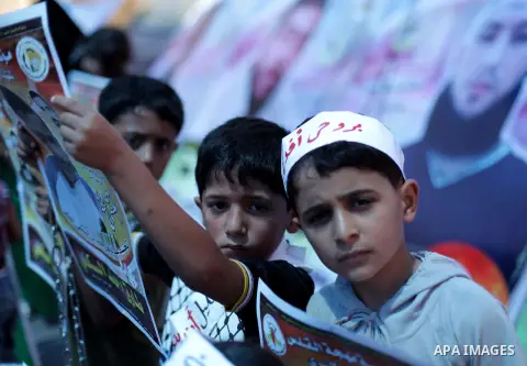 Palestinian children hold banners during a protest in front of the Red Cross in Gaza city on June 26, 2013 in solidarity with Palestinian and Jordanians prisoners held by Israel to demand their release from detention wit...
