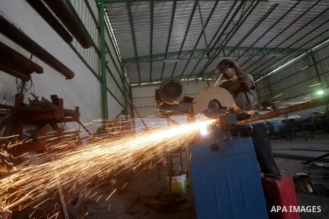 A Palestinian laborer works at a production line of tipper tri-motorcycles in Khan Younis in the southern Gaza Strip June 27, 2013. The Production Line is the first of its kind in Gaza Strip which Imports raw materials f...