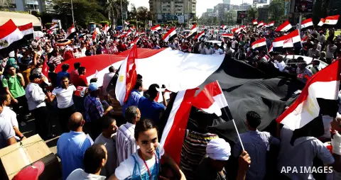 Protesters opposing Egyptian President Mohamed Mursi carry a huge flag as they march to Tahrir square from Mustafa Mahmoud mosque in Cairo June 30, 2013. Mass demonstrations across Egypt on Sunday may determine its futur...