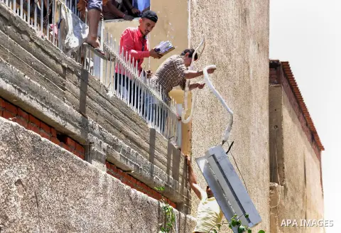 An Egyptian man carries things looted from the headquarters of the Muslim Brotherhood, in the al-Moqattam suburban, Cairo, Egypt, 01 July 2013. Medics said at least 12 people were killed in the fighting that started 30 J...