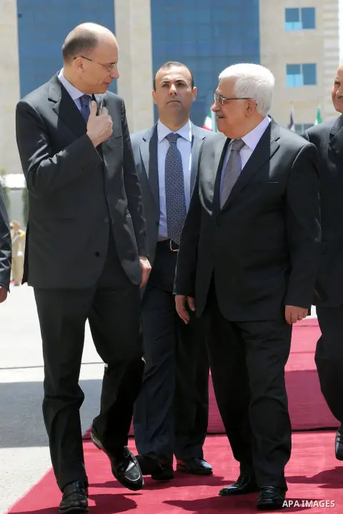 Italian Prime Minister Enrico Letta, Left, walks with Palestinian President Mahmoud Abbas past an honor guard during a welcome ceremony in the West Bank city of Ramallah, Tuesday, July 2, 2013. Photo by Thaer Ganaim