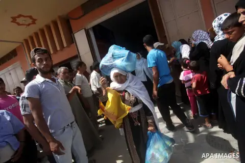 Palestinians receive their food aid from the charity in Deir al-Balah in central Gaza Strip, on July 9, 2013.as people prepare for the upcoming Muslim holy fasting month of Ramadan. Muslims around the world celebrate Ram...