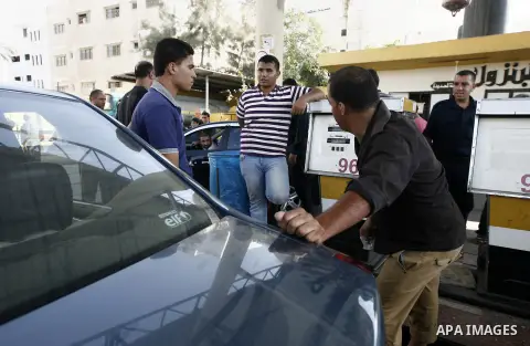 A Palestinian employee fills a car with benzin at a fuel station in Gaza city on July 09, 2013. Smugglers resumed pumping fuel to the Gaza Strip through tunnels under the Egyptian border Sunday, easing a fuel crisis in t...